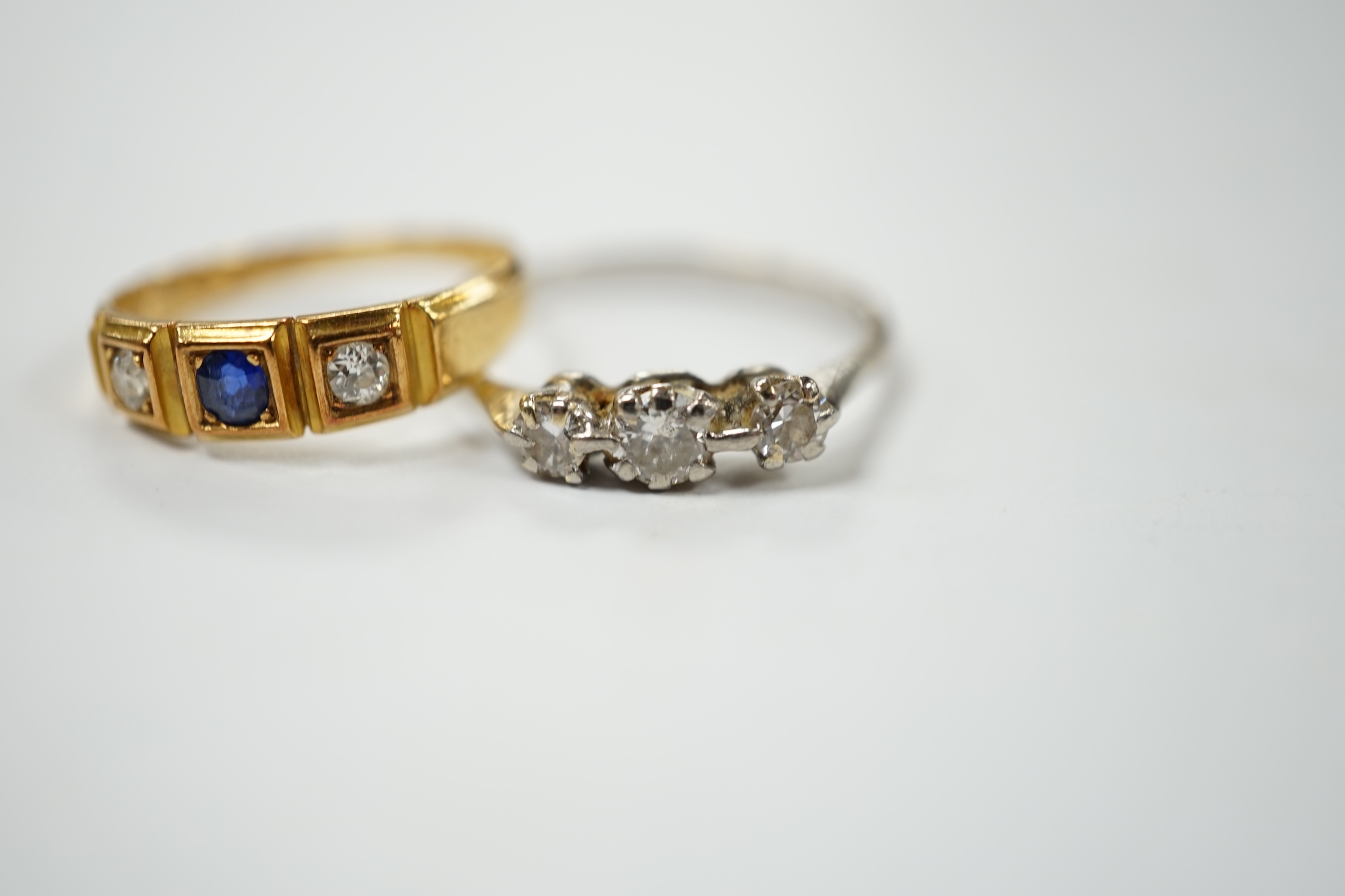 An Edwardian 18ct gold sapphire and diamond set three stone ring, size L, together with a white metal and three stone diamond ring, size N, gross weight 4.7 grams. Condition - fair